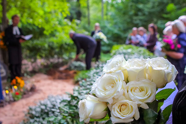 People hold flowers during a funeral service