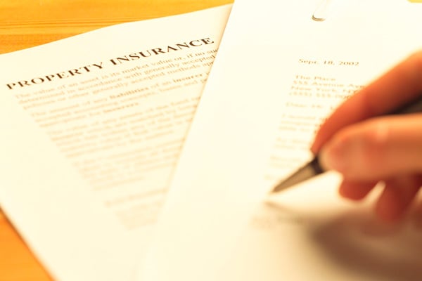 A property insurance form being signed