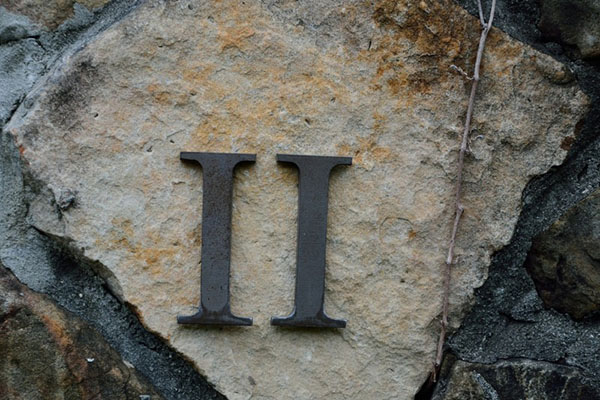 Metal Roman numeral II on top of a flat stone