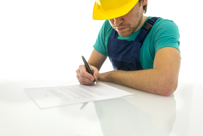 Construction worker signing a contract