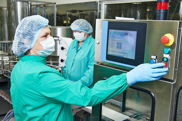 Two people working production line, wearing medical masks