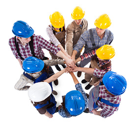 Construction workers in a group with all hands In