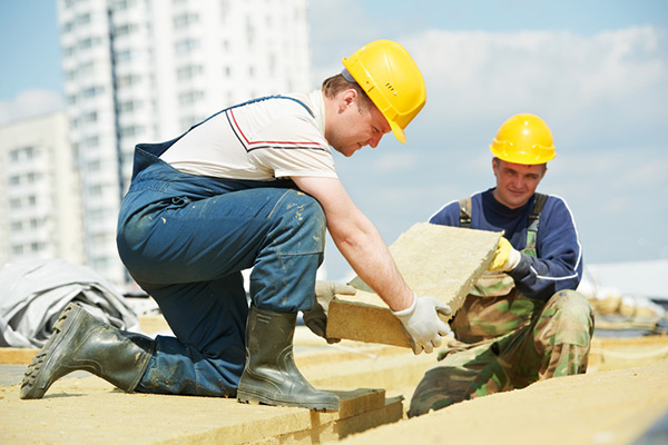 Two construction workers placing wooden panels