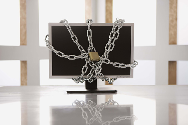 A computer monitor with chains and a padlock on it