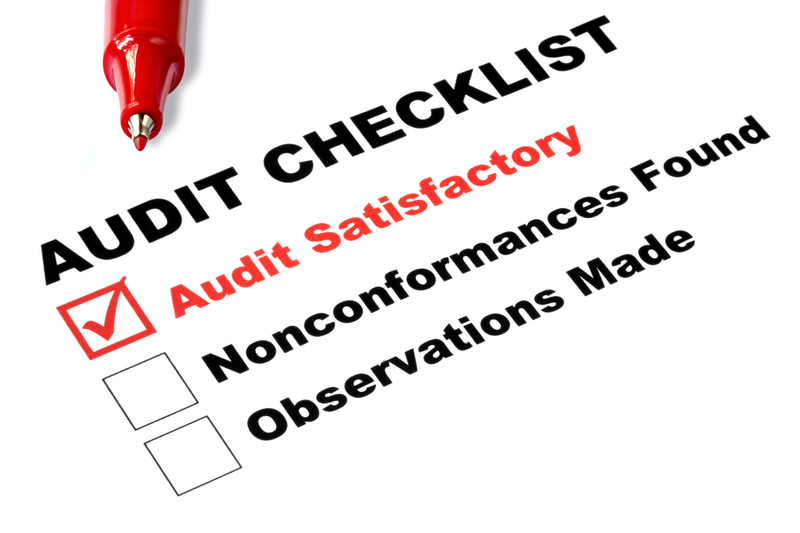 Audit checklist with a red pen and checmarked box