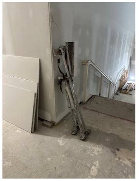 Stilts resting against installed drywall at construction site