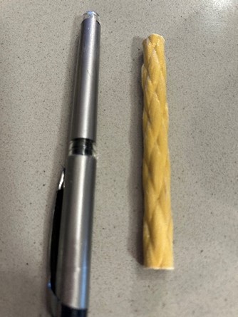 Photo of an aramid fiber rod next to a pen for scale