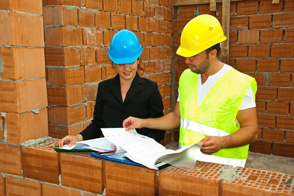 Two construction workers studying paperwork