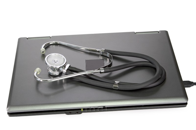 Stethoscope laying on top of a laptop
