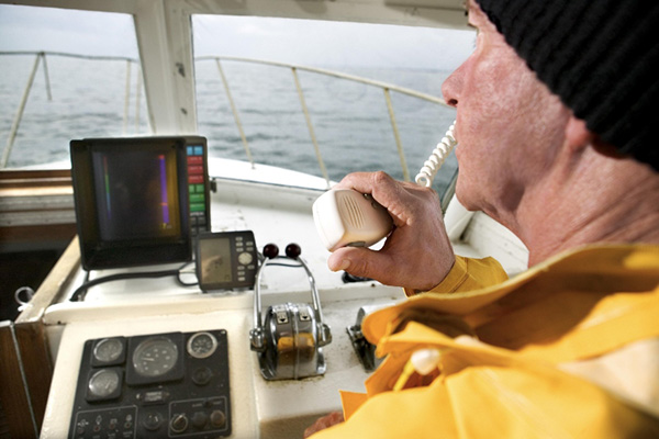 A sailor at the helm of a ship using radio