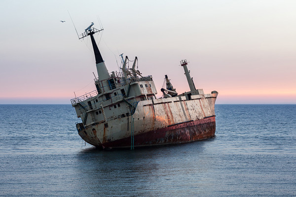 A rusted ship sinking at sea