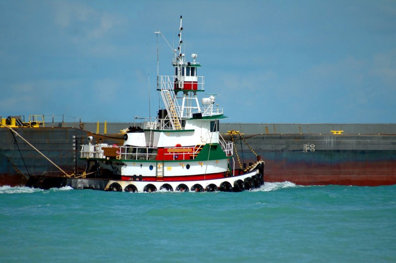 Tugboat pulling a barge in a Florida inlet