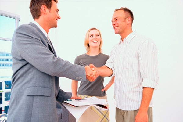Couple shaking hands with businessman