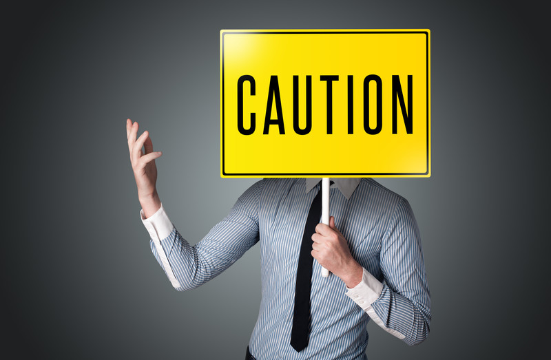 Businessman holding caution sign