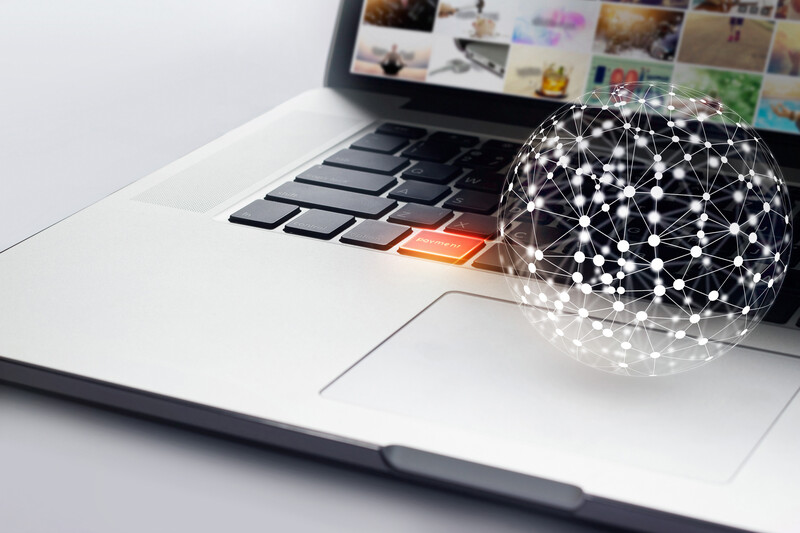A laptop and sphere with white data points connected above mousepad