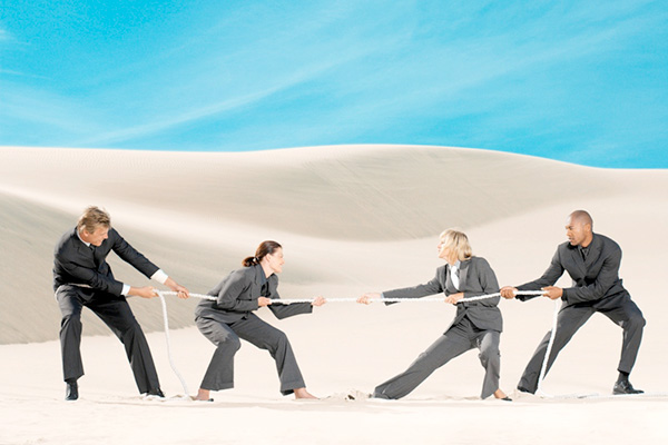 Business people in a tug of war in the desert