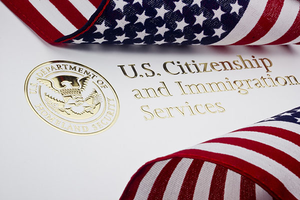 US Citizenship and Immigration Services logo with American flag ribbons