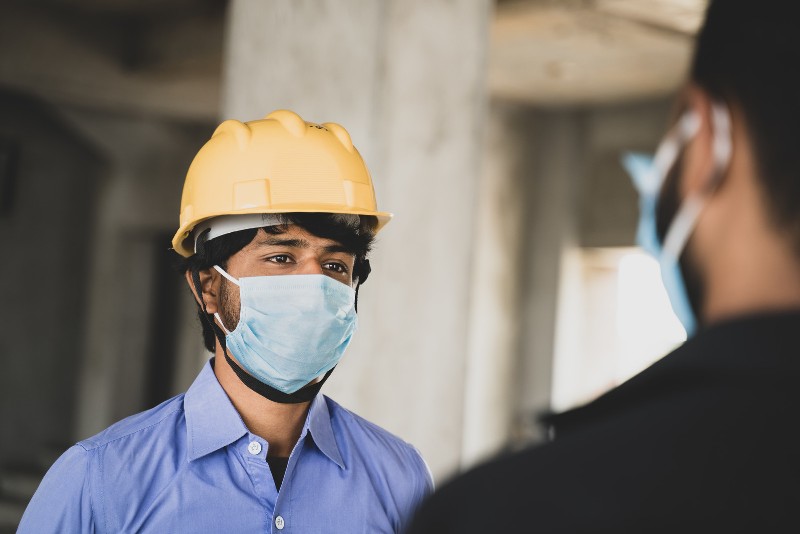 Two construction workers wearing medical face masks