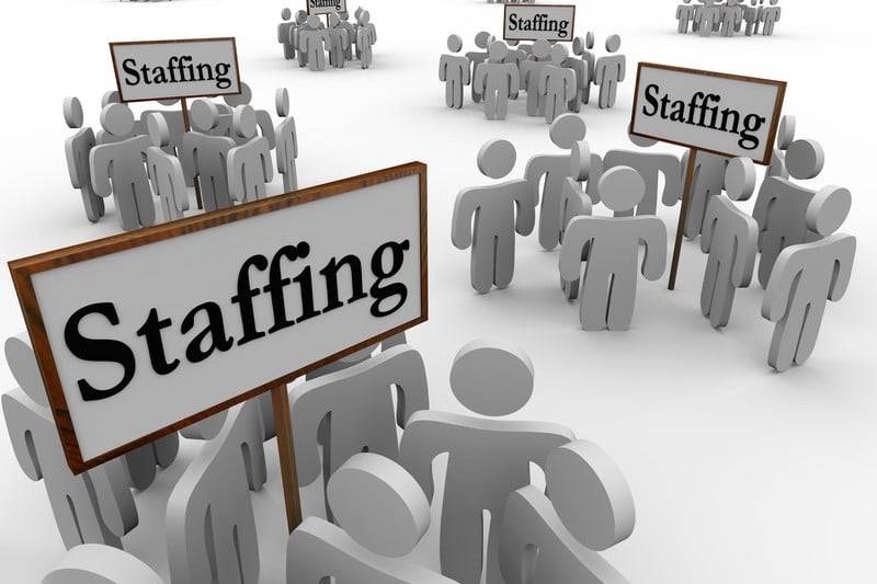 Stick people grouped around signs that say staffing