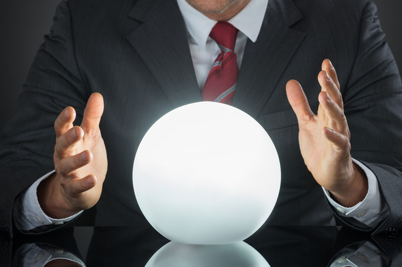 Torso of businessman with hands around crystal ball