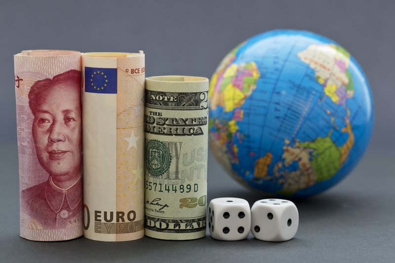 Yuan, Euro, dollar, dice, and a globe