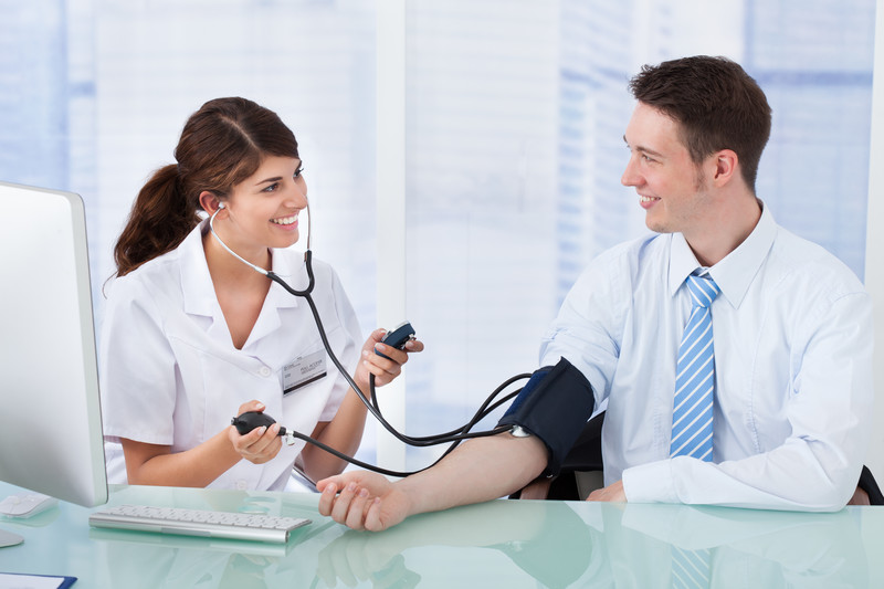 Businessman getting blood pressure checked by a nurse