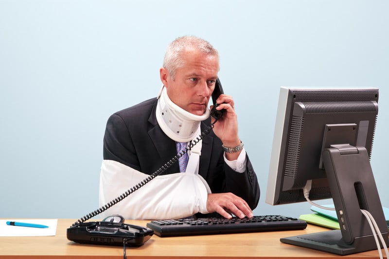 Injured businessman at his desk