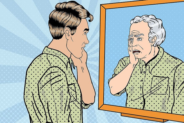 Younger man looking at older version of self in mirror