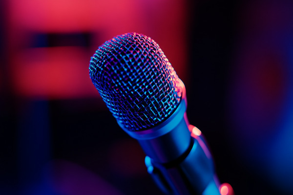 A close-up image of a microphone under blue and red lights