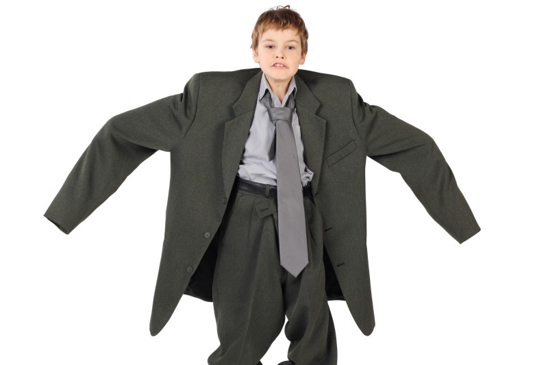 Little boy wearing a big man's business suit