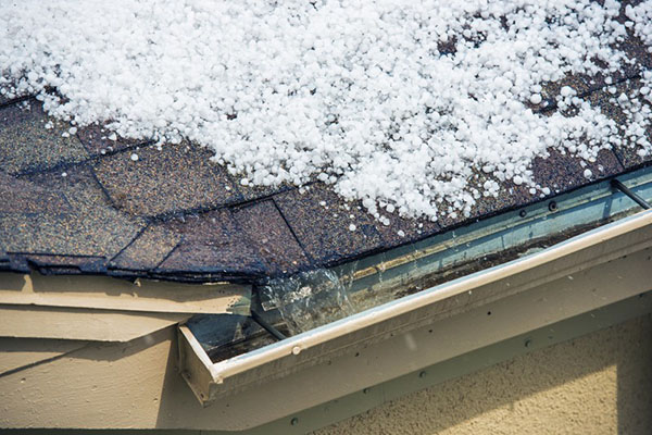 Hail melting on top of a roof plus damage to the roof