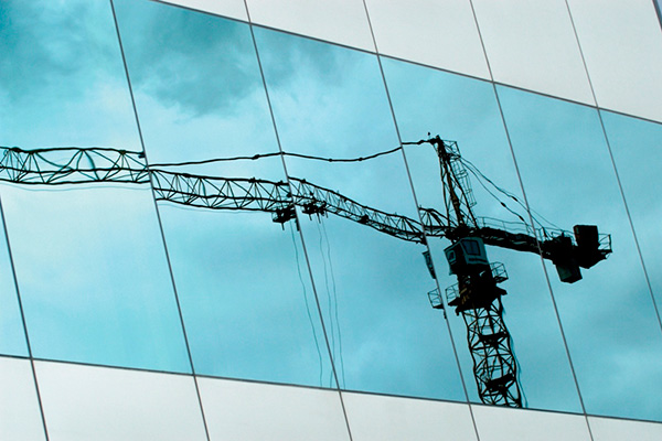 Reflection of a crane on a high-rise's windows