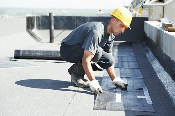 Worker fixing damaged commercial roof